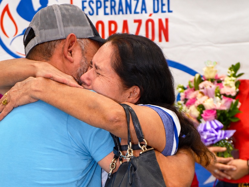 Un hombre y una mujer se abrazan con emoción durante un reencuentro familiar